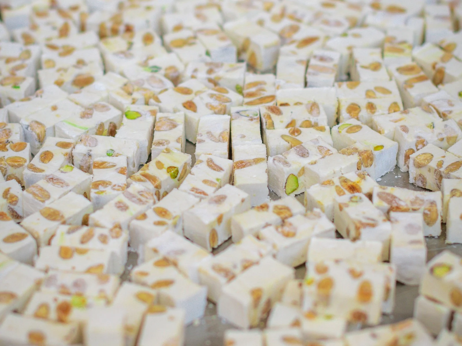 Nougat de Montélimar coupé en cubes, amandes et pistaches apparentes, dans une nougaterie de Montélimar